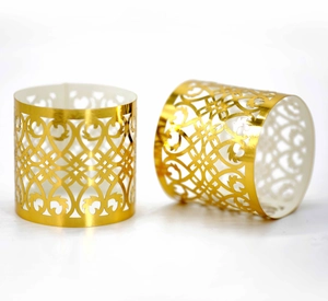 Detailed close-up of two rose gold laser-cut napkin rings with intricate floral patterns