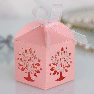 Close-up of pink laser-cut tree design gift box with ribbon and pearlescent paper
