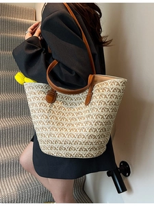 Borsa tote in paglia fatta a mano con manici in pelle marrone e ciondolo a fiore giallo