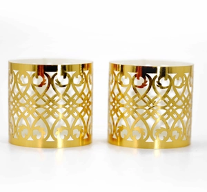 Close-up of laser-cut rose gold napkin rings with intricate hollowed heart patterns