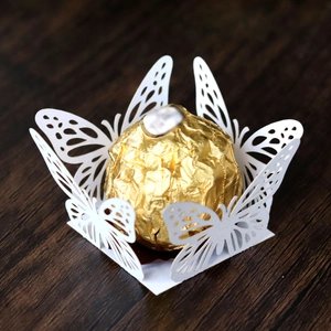 Macro shot of laser-cut white butterfly candy holder for festive party decorations