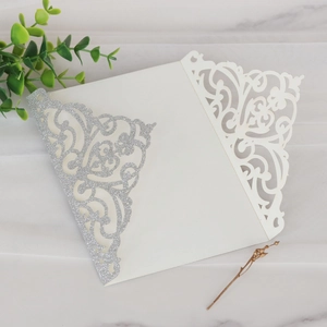 Détail d'invitation de mariage découpée au laser avec paillettes et finition élégante