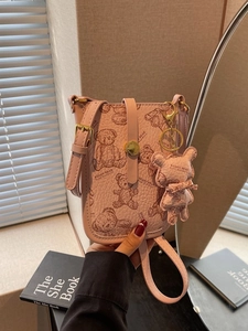 Pink crossbody phone bag with teddy bear print and matching charm accessory