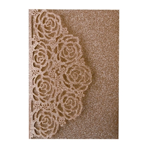 Detailed laser cut rose flower pattern on rose gold glitter wedding invitation card