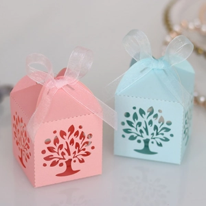 Close-up of laser-cut Tree of Life candy boxes with elegant organza ribbon bows