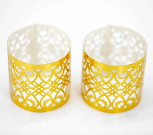 Detailed laser-cut gold napkin rings with elegant heart pattern and mirror finish