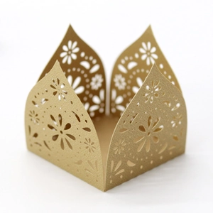 Macro detail of laser-cut crown paper box with intricate daisy patterns for wedding favor
