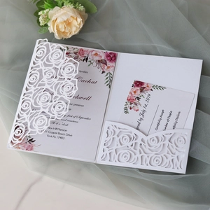 Detail of laser-cut ivory rose wedding invitation set with floral RSVP and main card