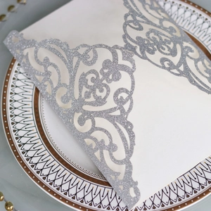 Vue macro de l'étui d'invitation argenté pailleté avec motif floral découpé au laser