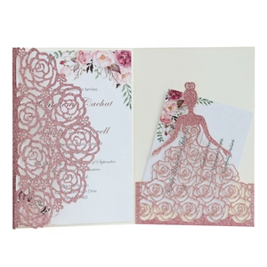 Macro detail of laser-cut rose gold glitter wedding invitation with floral insert