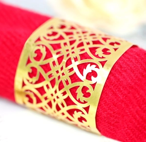 Macro detail of gold reflective hollow-carved napkin ring with baroque laser-cut pattern
