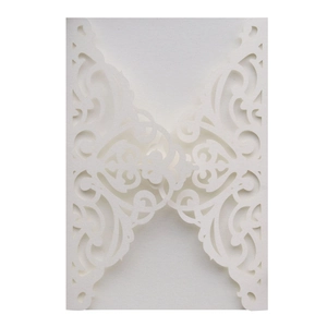 Macro detail of laser-cut pearl paper wedding invitation with floral lace patterns