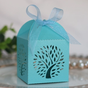 Detail of light blue laser-cut tree gift box with elegant organza ribbon bow