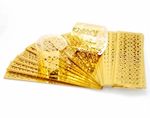 Detail of laser-cut gold napkin rings with hollow heart patterns for table decor