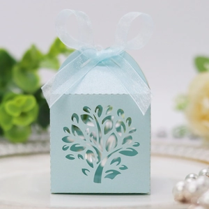 Close-up of light blue laser-cut tree candy box with elegant organza ribbon bow