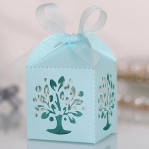 Close-up of light blue laser-cut tree design on wedding candy gift box with ribbon