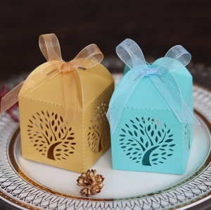 Laser-cut Tree of Life candy boxes in champagne gold and light blue with organza ribbons