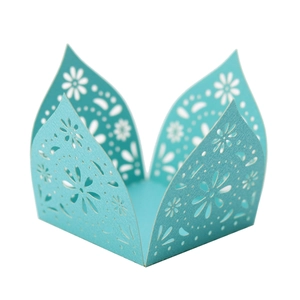Close-up of laser-cut floral patterns on a light blue pearlescent paper candy holder