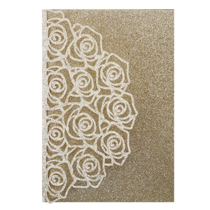 Detail of laser-cut rose lace wedding invitation cover in gold glitter cardstock