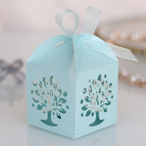 Detailed laser-cut tree design on a light blue candy gift box with a silk ribbon bow