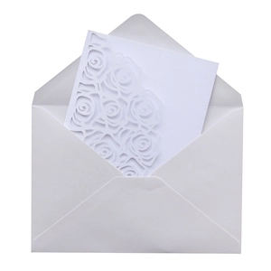 Macro view of laser-cut rose patterns on white pearlescent paper wedding invitation