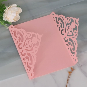 Macro detail of laser-cut floral invitation cover in elegant pearlescent pink paper