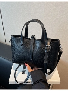 Elegant black textured leather handbag with a top handle and adjustable shoulder strap