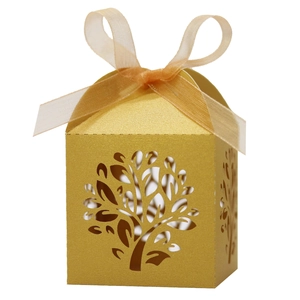 Detail showing laser-cut tree pattern on a gold favor box with a satin ribbon