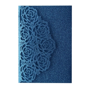 Close-up of navy blue glitter invitation with laser-cut rose hollow patterns