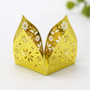 Close-up of laser-cut gold daisy hollow decorative cupcake wrappers for wedding favors