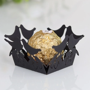 Close-up of black laser-cut candy box with intricate bird pattern and hollow lace