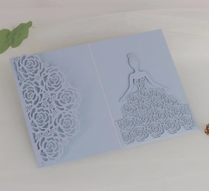 Detail of light blue laser-cut wedding invitation featuring rose patterns and a bride silhouette