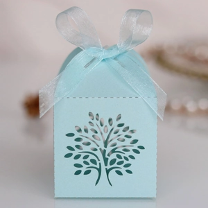 Detail of light blue laser-cut tree candy box with an elegant organza ribbon bow