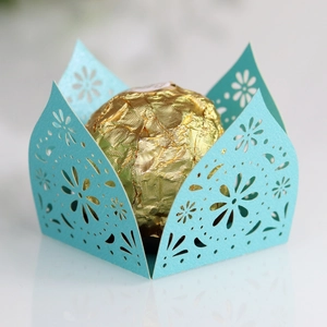 Macro view of sky blue laser-cut paper chocolate holder with hollow floral patterns