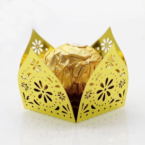 Macro detail of laser cut hollow gold chocolate box with elegant floral pattern edges
