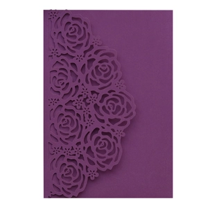 Detail of laser-cut rose floral patterns on dark red wedding invitation card