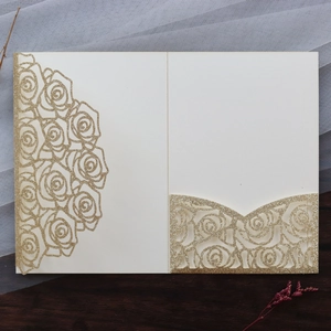 Detail of laser-cut rose pattern wedding invitation with champagne gold glitter finish