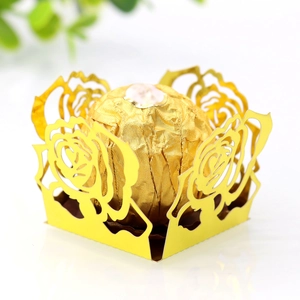 Détail du support en papier doré découpé au laser avec motif rose pour chocolat et truffe
