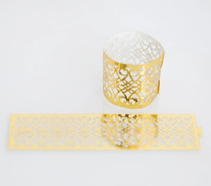 Detail view of gold laser-cut napkin rings with hollow heart patterns for weddings