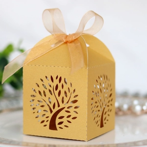 Detail of laser-cut Tree of Life wedding favor box in gold with ribbon bow
