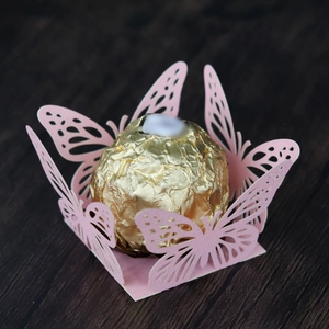Macro shot of laser-cut hollow butterfly candy box in light pink for weddings