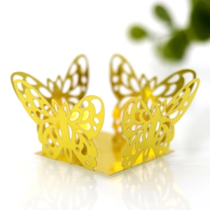 Detailed view of golden laser-cut butterfly cupcake wrappers with intricate hollow design