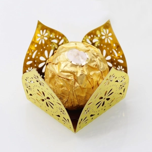 Detail of gold laser-cut hollow chocolate wrappers with intricate floral patterns