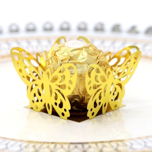 Macro shot of gold laser-cut butterfly chocolate holder for wedding party decoration