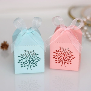 Detailed laser-cut tree design on blue and pink paper candy boxes with organza ribbons