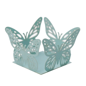 Detail of light blue laser-cut cupcake wrapper with butterfly pattern for party decor
