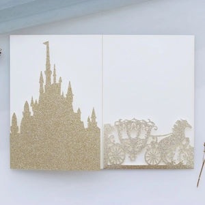 Detail der glitzernden goldenen lasergeschnittenen Hochzeitseinladung mit Schloss