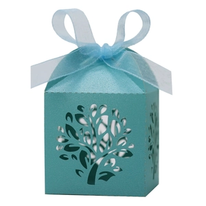 Detail of light blue laser-cut candy box with tree of life pattern and ribbon bow
