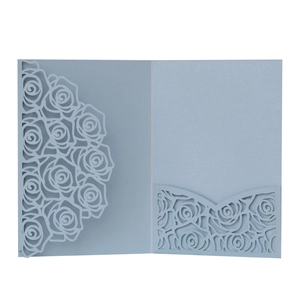 Detailed laser cut rose patterns on light blue pearlescent paper wedding invitation