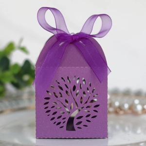 Detail of laser-cut Tree of Life wedding favor box in purple with elegant ribbon bow